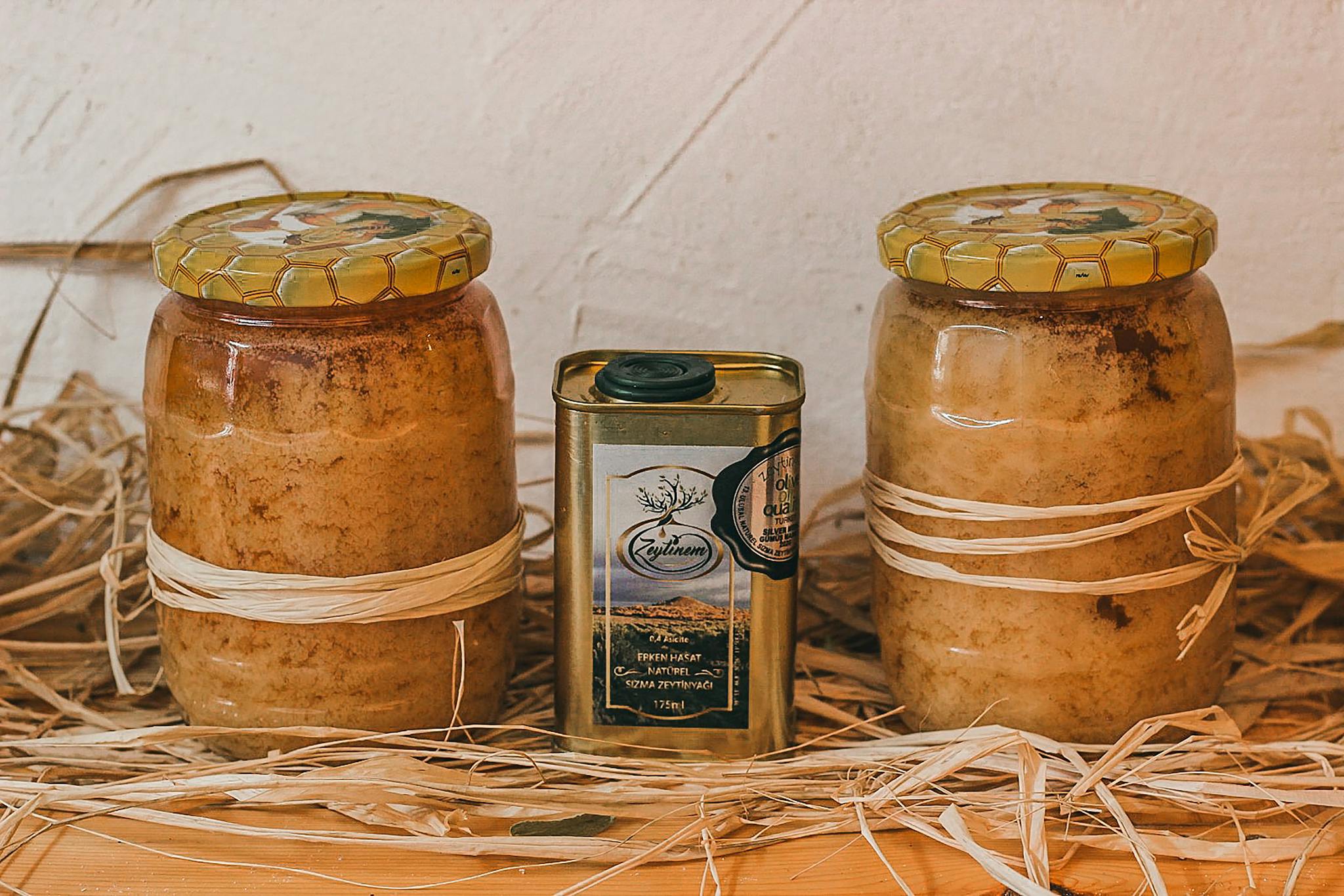 Homemade honey jars and olive oil can in a rustic setup. Perfect for organic food themes.